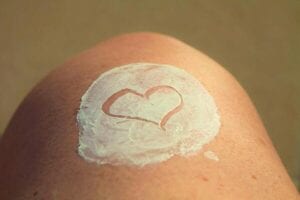 Lotion on a leg, in the shape of a heart--keep skin healthy year-round by following these Skincare tips from ASC Dermatologist, Dr. Rand Werbitt.