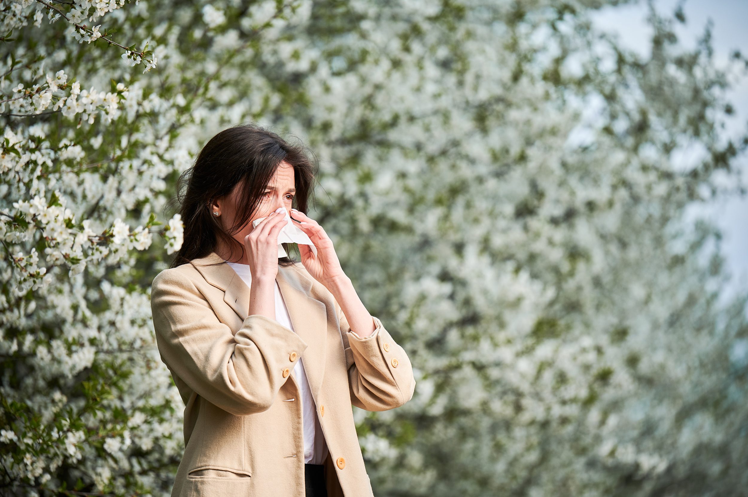 Woman suffering from seasonal allergies outdoors — adult allergy symptoms and treatment options at Advanced Specialty Care CT.